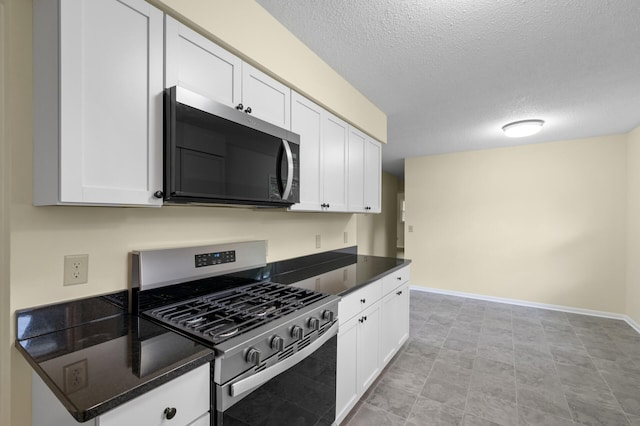 2756 Sunset Ln, Burnsville, MN 55337 - kitchen featuring appliances with stainless steel finishes, dark countertops, white cabinets, and a textured ceiling