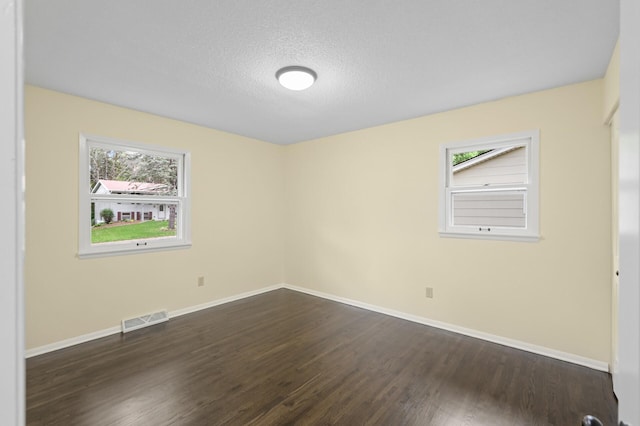 2756 Sunset Ln, Burnsville, MN 55337 - unfurnished room with plenty of natural light, dark wood-style flooring, baseboards, and a textured ceiling