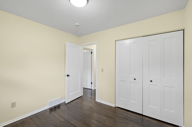 2756 Sunset Ln, Burnsville, MN 55337 - unfurnished bedroom featuring dark wood-style flooring, baseboards, a closet, and a textured ceiling