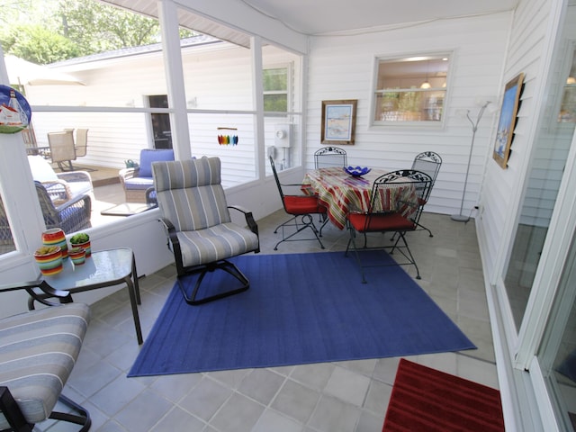 sunroom with outdoor dining space and tile patterned floors
