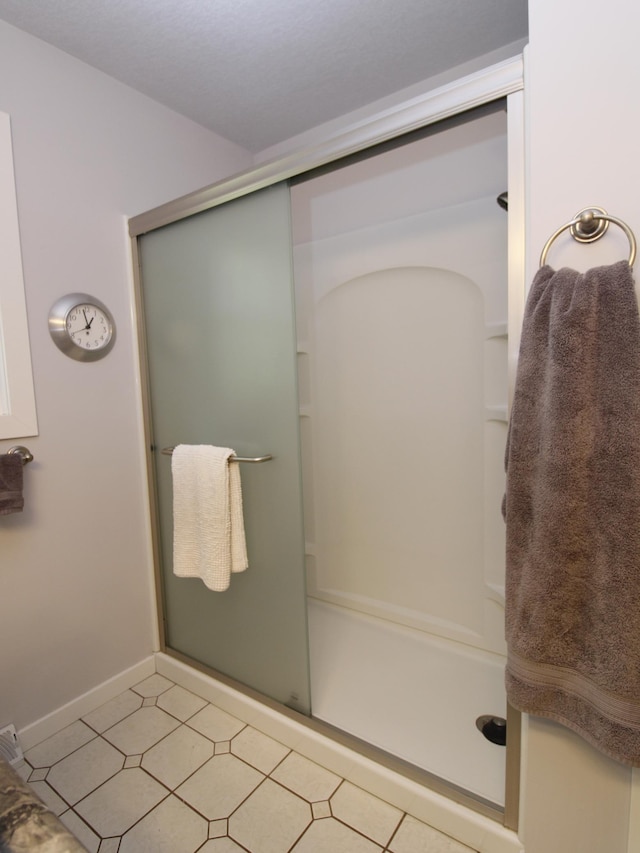 full bathroom featuring a stall shower and baseboards