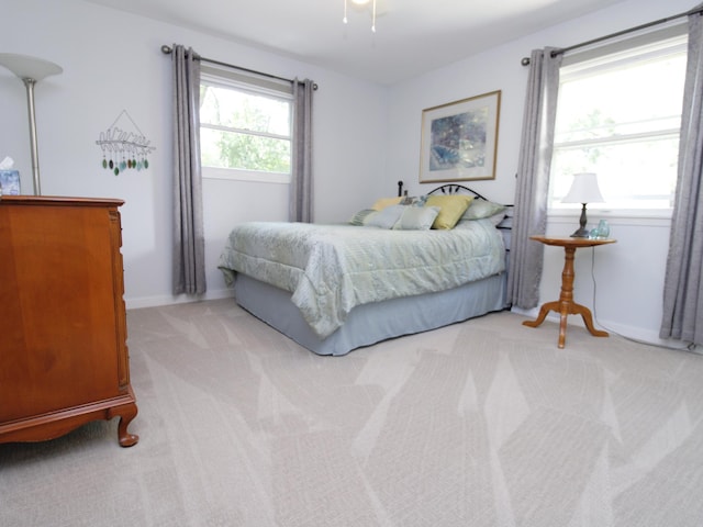 bedroom featuring light colored carpet and baseboards
