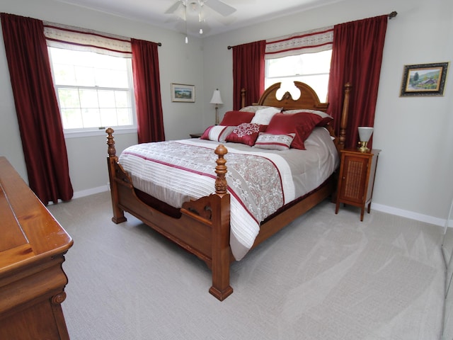 bedroom featuring light carpet, baseboards, and multiple windows