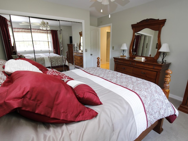 carpeted bedroom with a closet, ceiling fan, and baseboards