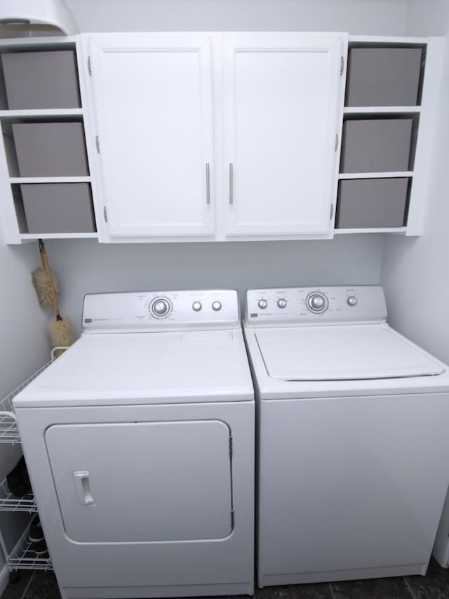 clothes washing area featuring washer and clothes dryer and cabinet space