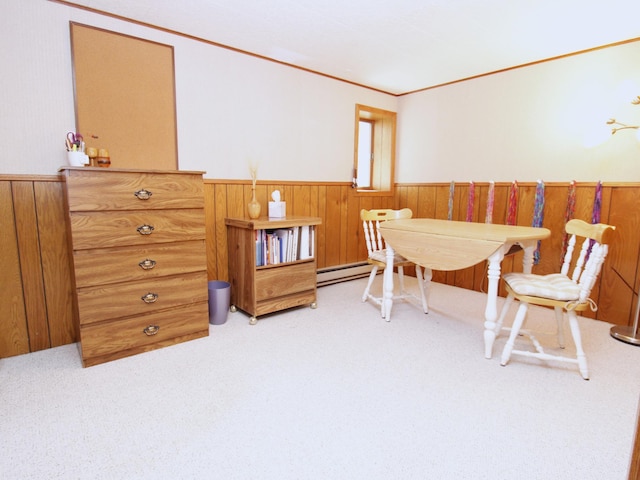 carpeted dining area with a wainscoted wall, wood walls, and ornamental molding