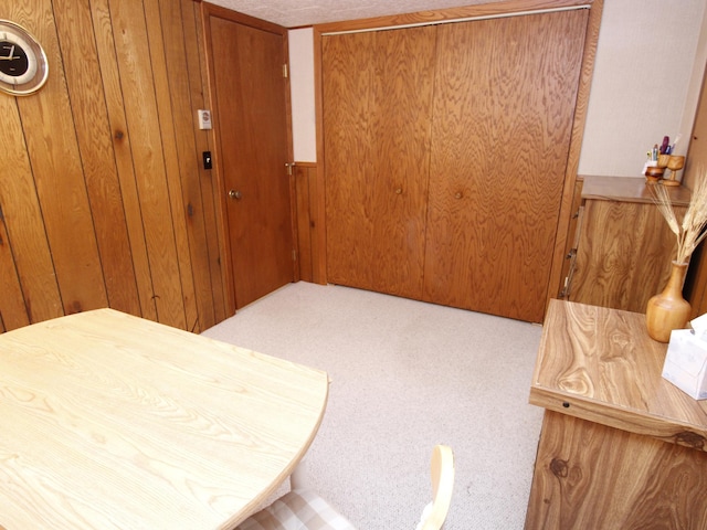 carpeted foyer featuring wood walls