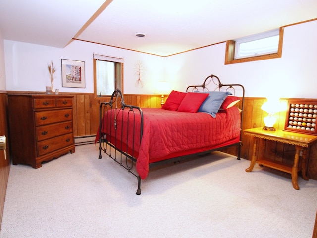 carpeted bedroom with wainscoting, a baseboard heating unit, and wooden walls