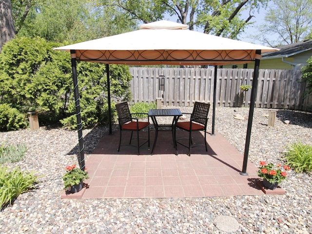 view of patio / terrace featuring fence, outdoor dining space, and a gazebo