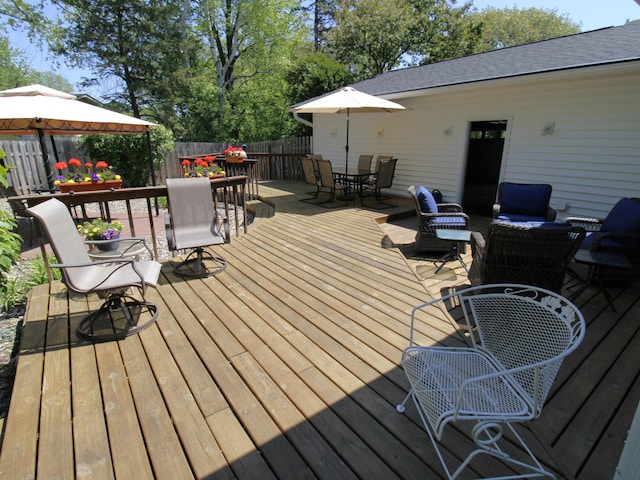 wooden deck featuring outdoor dining space, fence, a gazebo, and outdoor lounge area