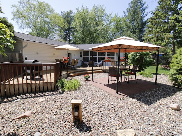 back of property featuring a gazebo, a deck, and outdoor dining area