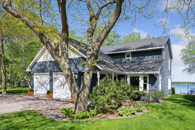 10547 Hollister Ave NW, Maple Lake, MN 55358 - view of front facade with a front lawn, driveway, a shingled roof, an attached garage, and a water view