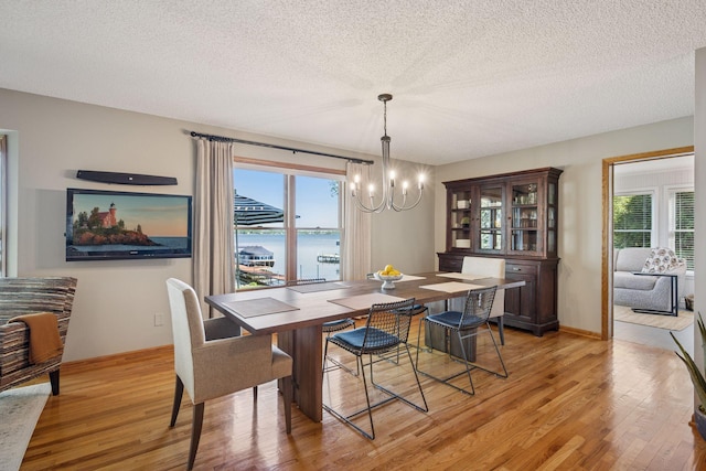 10547 Hollister Ave NW, Maple Lake, MN 55358 - dining room with a chandelier, light wood-type flooring, a textured ceiling, and baseboards