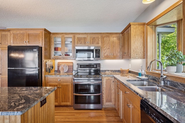 10547 Hollister Ave NW, Maple Lake, MN 55358 - kitchen with black appliances, a sink, light wood-type flooring, a textured ceiling, and dark stone countertops