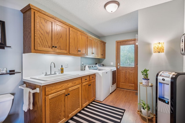 10547 Hollister Ave NW, Maple Lake, MN 55358 - laundry area with washing machine and dryer, light wood-style floors, and a textured ceiling