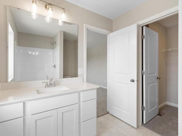 full bath with a shower, vanity, tile patterned floors, and baseboards