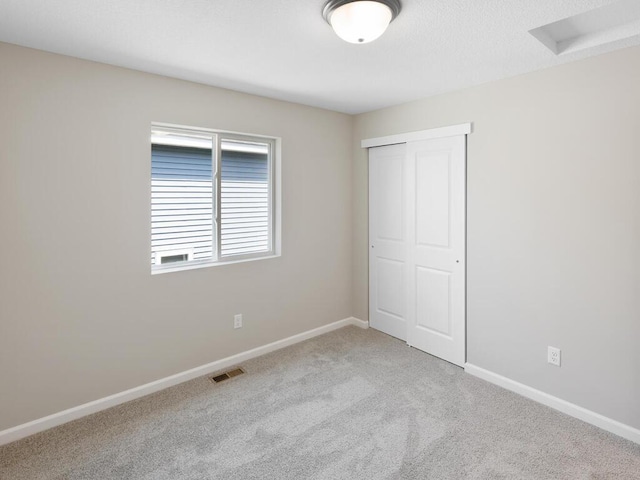 unfurnished bedroom featuring carpet, a closet, and baseboards