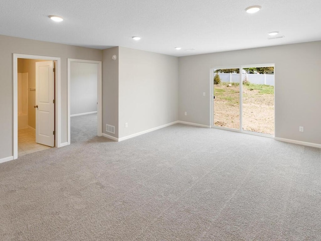 carpeted spare room featuring baseboards and recessed lighting