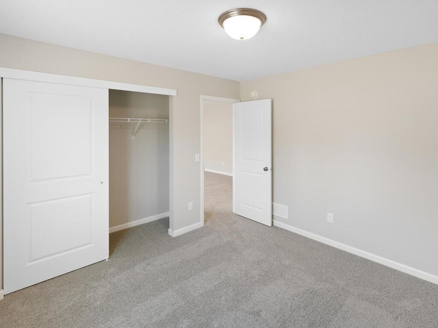 unfurnished bedroom featuring carpet, a closet, and baseboards