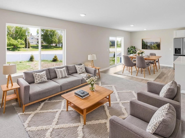 living area with recessed lighting, baseboards, and light wood finished floors