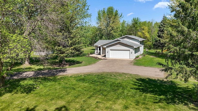 10330 253rd St, Chisago Lake Twp, MN 55013 - view of grassy yard with driveway, a wooded view, and an attached garage