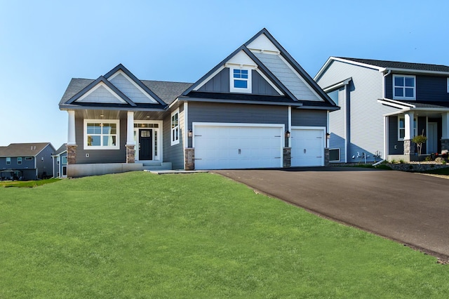 craftsman inspired home with asphalt driveway, a front yard, stone siding, board and batten siding, and an attached garage