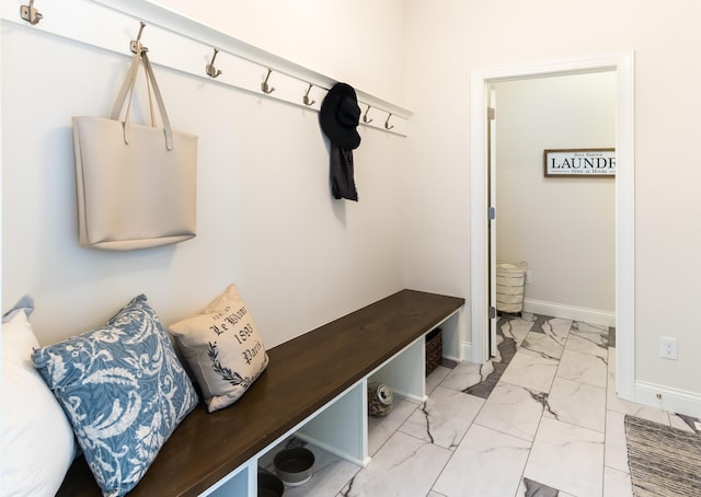 mudroom featuring light marble finish flooring and baseboards