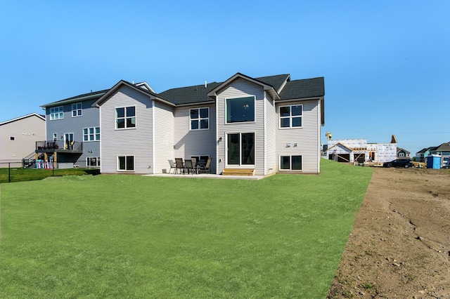 back of property featuring a lawn and a patio