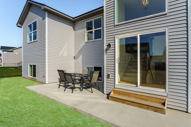 rear view of house with a patio and a yard