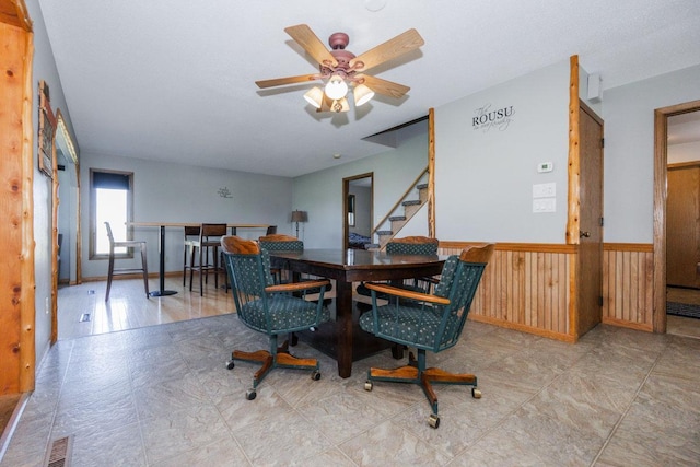 35445 County Highway 36, Vergas, MN 56587 - dining room with wainscoting, a ceiling fan, stairway, and wooden walls