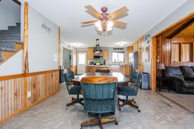 35445 County Highway 36, Vergas, MN 56587 - dining space with wooden walls, ceiling fan, stairway, and wainscoting