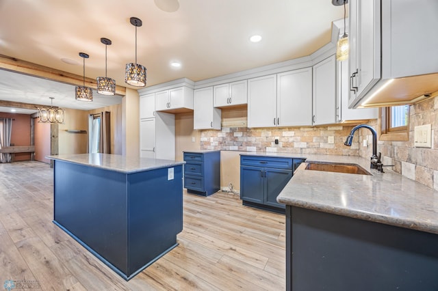 2318 15th St S Unit C11, Fargo, ND 58103 - kitchen with a sink, a kitchen island, decorative backsplash, blue cabinetry, and recessed lighting
