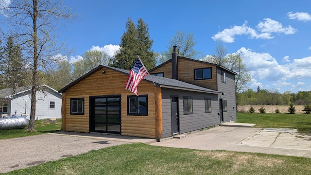 rear view of house featuring a lawn and a patio