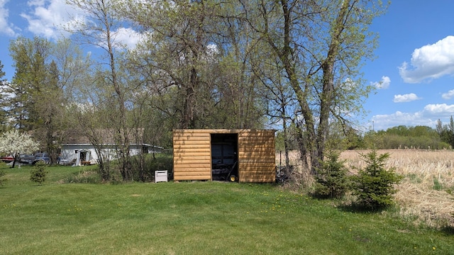 view of green lawn with a storage unit and an outbuilding