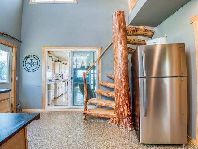 kitchen with freestanding refrigerator, speckled floor, and dishwasher