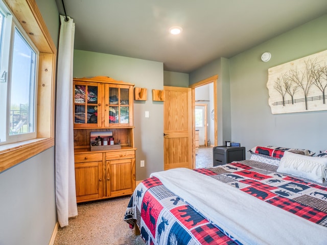 bedroom with multiple windows and dark speckled floor
