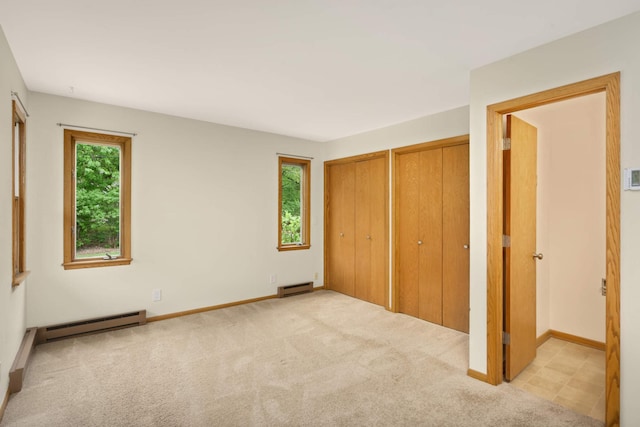2479 Oxford St N, Roseville, MN 55113 - unfurnished bedroom with baseboard heating, two closets, carpet floors, and baseboards