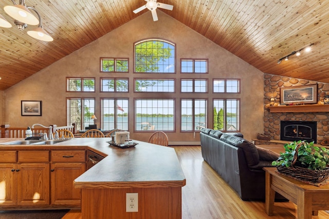 1823 313th Ave NE, Isanti Twp, MN 55008 - kitchen featuring a sink, open floor plan, high vaulted ceiling, brown cabinetry, and a stone fireplace