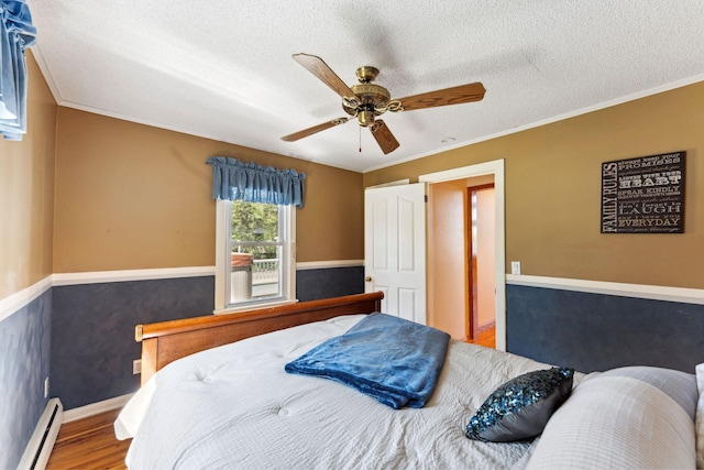 1823 313th Ave NE, Isanti Twp, MN 55008 - bedroom with baseboard heating, a textured ceiling, wood finished floors, crown molding, and ceiling fan