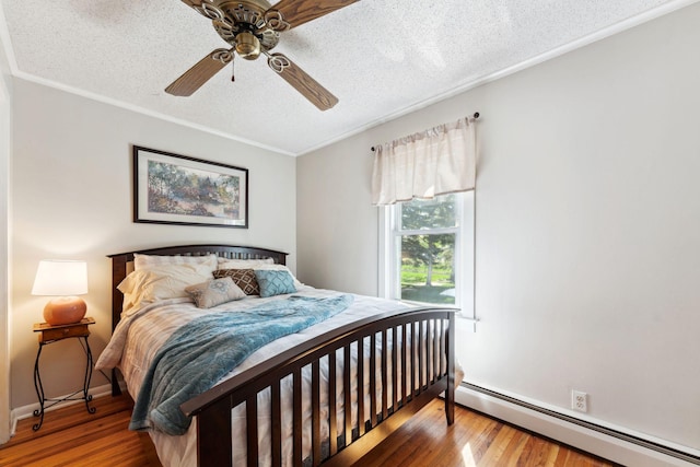 1823 313th Ave NE, Isanti Twp, MN 55008 - bedroom with a baseboard heating unit, a textured ceiling, wood finished floors, crown molding, and a ceiling fan