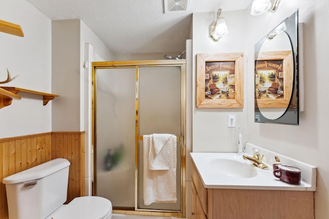1823 313th Ave NE, Isanti Twp, MN 55008 - bathroom with toilet, vanity, a stall shower, a wainscoted wall, and a textured ceiling