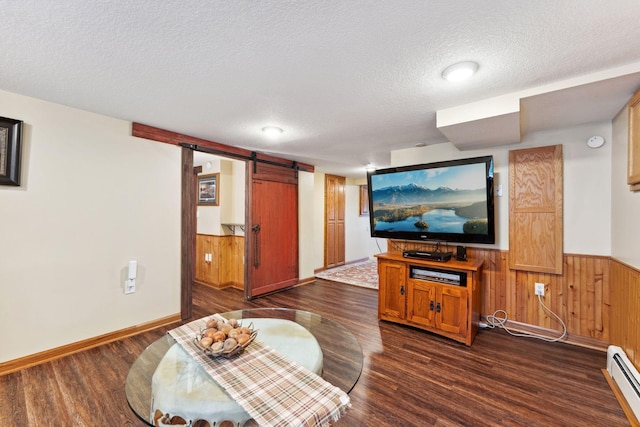 1823 313th Ave NE, Isanti Twp, MN 55008 - living room with a barn door, baseboard heating, a textured ceiling, dark wood-style floors, and wainscoting