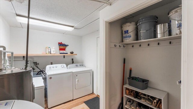 305 Arcadian Pl Unit 1, Buffalo, MN 55313 - washroom with washing machine and dryer, light wood-style floors, water heater, and a textured ceiling