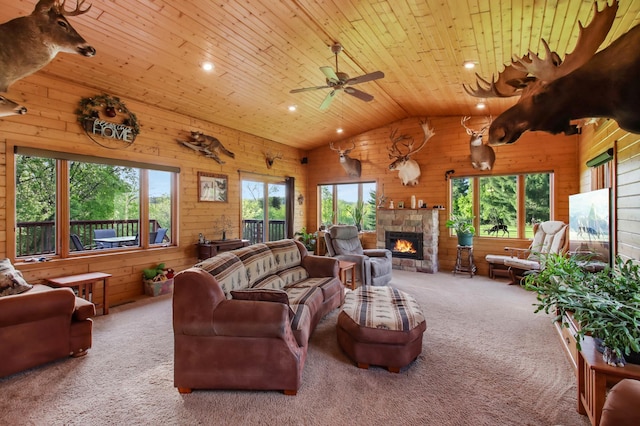 living area featuring wood walls, vaulted ceiling, plenty of natural light, carpet floors, and wood ceiling