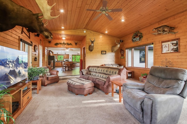 carpeted living room with a ceiling fan, wooden walls, lofted ceiling, and wooden ceiling