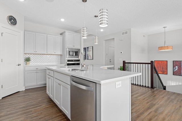 1501 Southpoint Dr, Hudson, WI 54016 - kitchen featuring stainless steel appliances, dark wood-type flooring, light countertops, tasteful backsplash, and white cabinetry