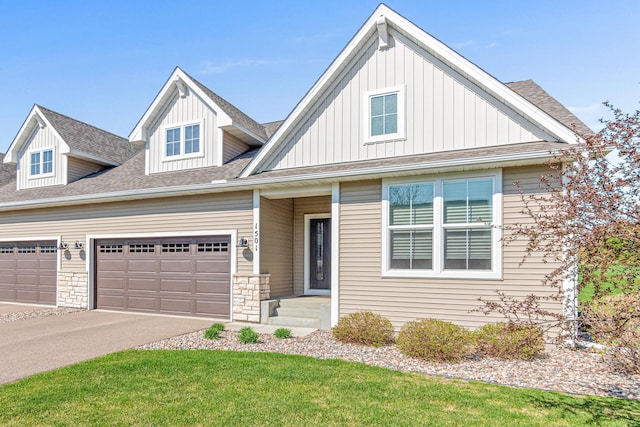 1501 Southpoint Dr, Hudson, WI 54016 - view of front of house featuring board and batten siding, a garage, roof with shingles, driveway, and a front lawn