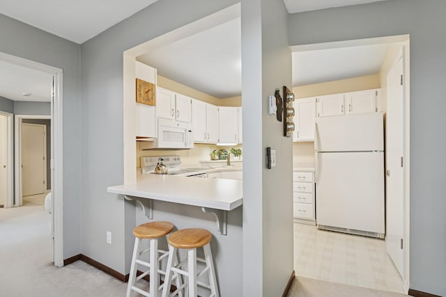2250 Ridge Dr Unit 11, Saint Louis Park, MN 55416 - kitchen featuring white appliances, light countertops, a breakfast bar area, white cabinets, and baseboards