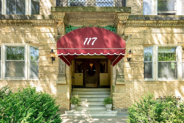 entrance to property featuring brick siding