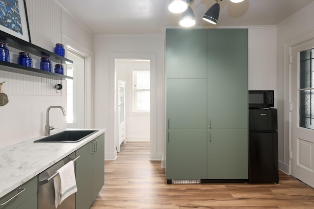 kitchen featuring black appliances, a sink, green cabinetry, light wood-type flooring, and ornamental molding